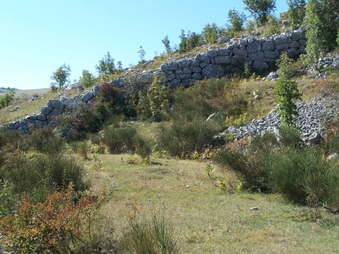 immagine della cinta muraria che scende rapidamente a valle, nell'area archeologica delle Civitelle